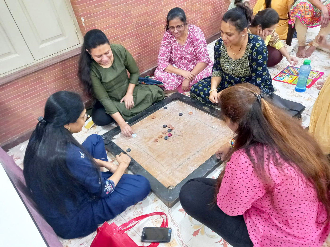 Ladies enjoying a spirited game of carrom at Hamaara Sapna
